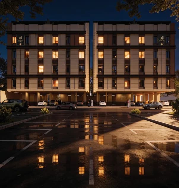 Building exterior at dusk, with dedicated resident parking at the front.