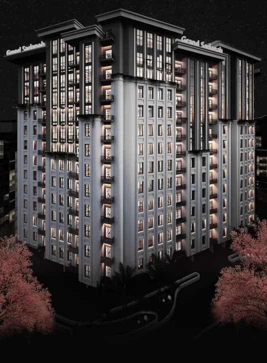 Grand Sadana by night — the twin residential wings illuminated above the landscaped grounds